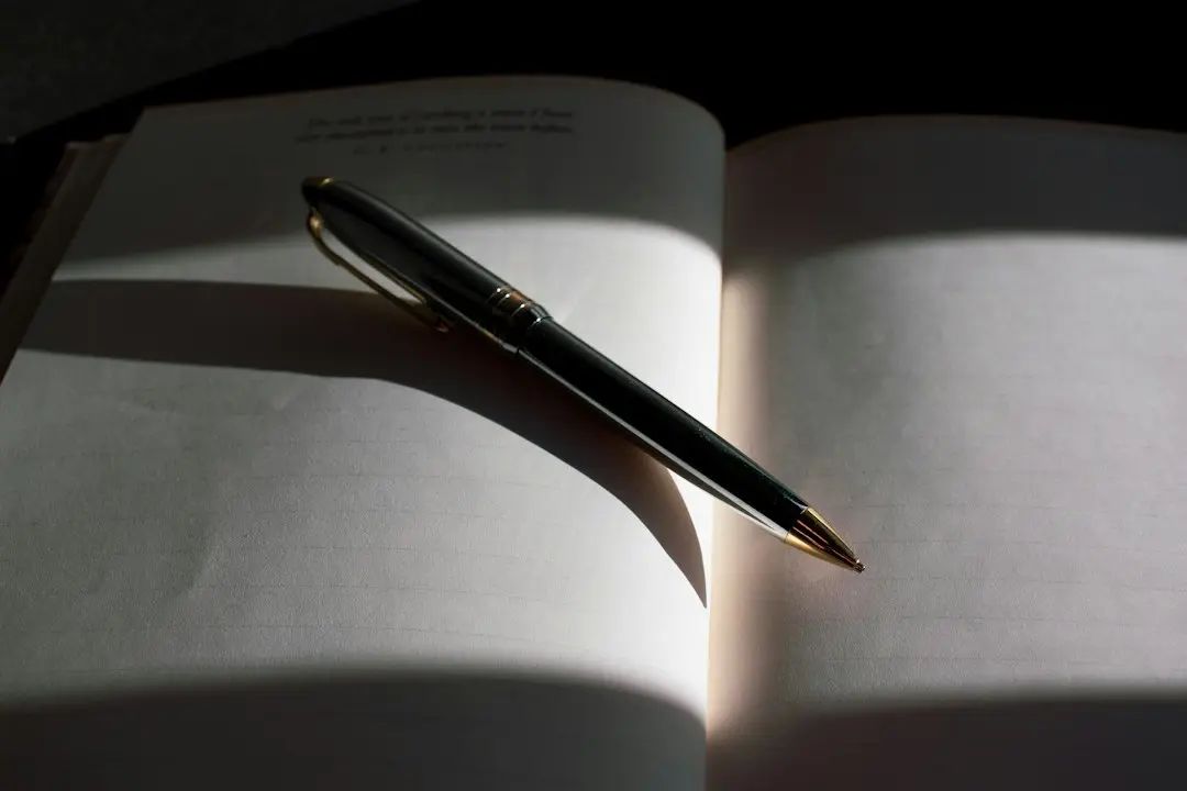 An open notebook with a pen lying across its pages in a band of sunlight, ready for a checklist to compare IPTV providers